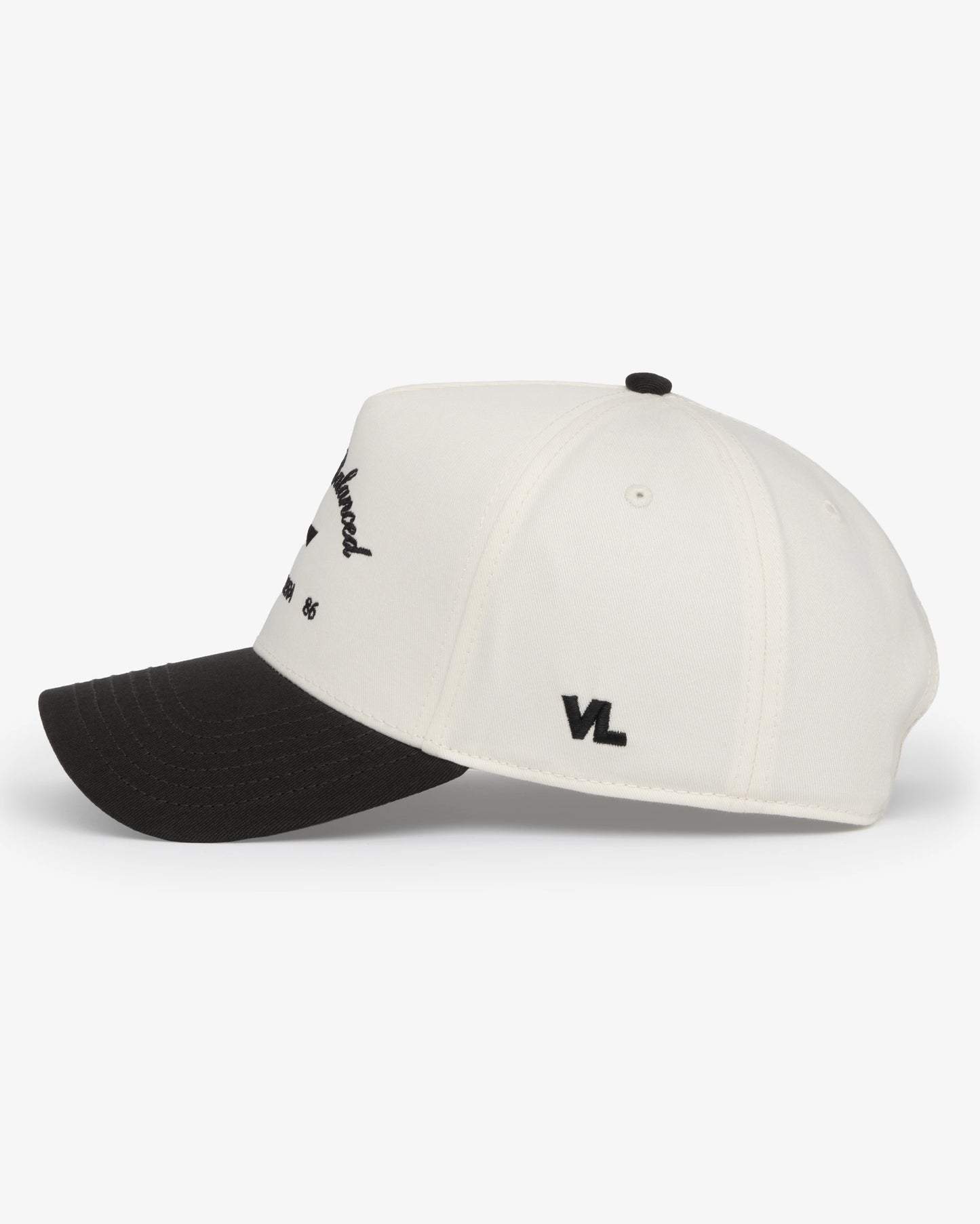 Van Libra Bone/Carbon (cream and dark gray) structured cap with bone colored crown and carbon colored brim. Features black embroidered text “Stay Balanced” with abstract triangle graphic on the front, “1986” and “VAN LIBRA” details, and “VL” stitched on the side, finished with an adjustable carbon colored snapback closure at the back.