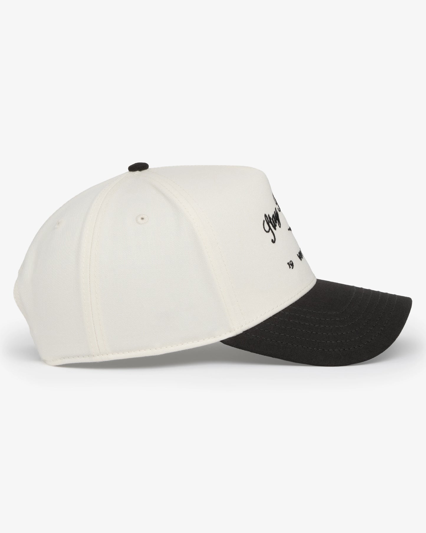 Van Libra Bone/Carbon (cream and dark gray) structured cap with bone colored crown and carbon colored brim. Features black embroidered text “Stay Balanced” with abstract triangle graphic on the front, “1986” and “VAN LIBRA” details, and “VL” stitched on the side, finished with an adjustable carbon colored snapback closure at the back.