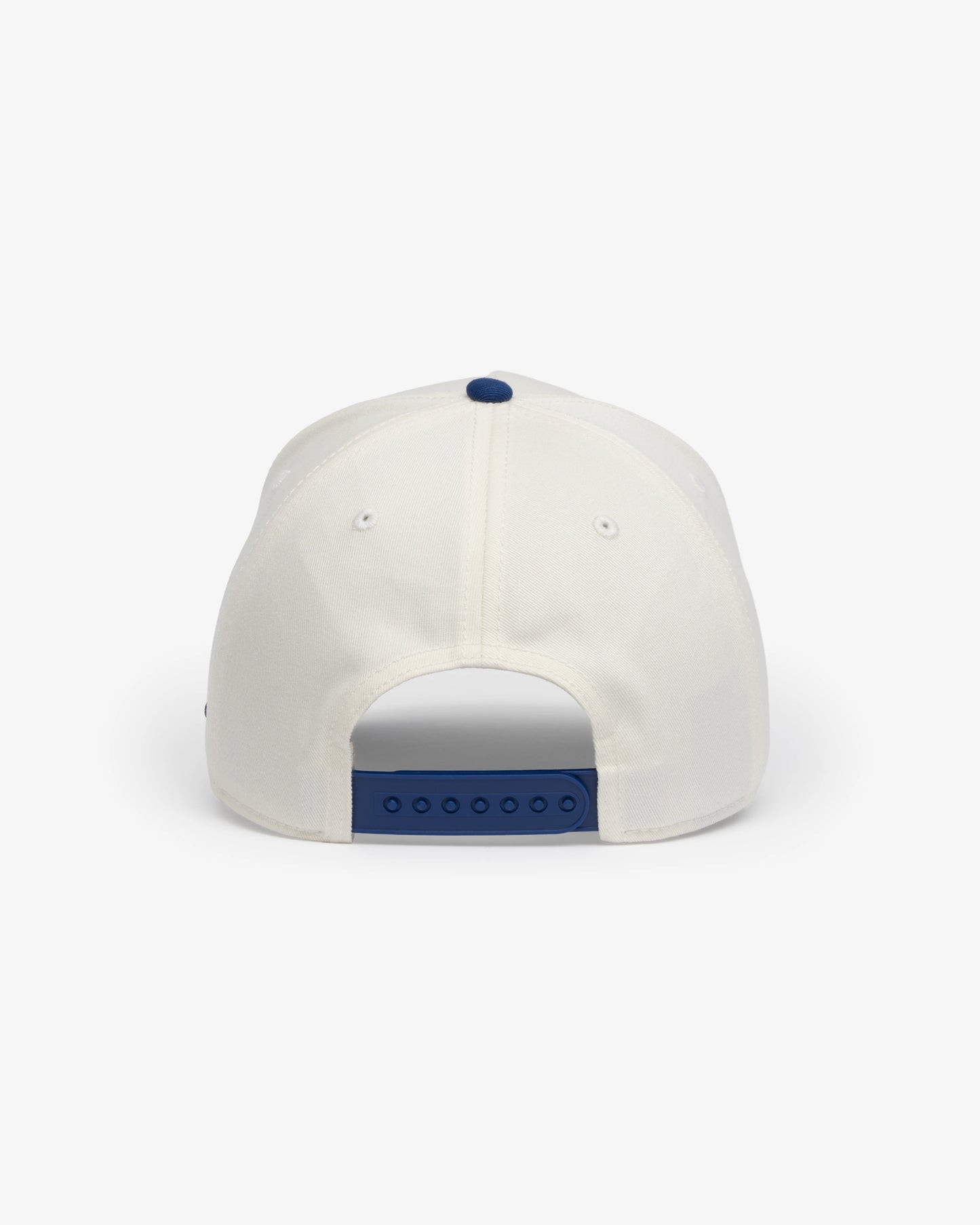 Van Libra Bone/Indigo (cream and blue) structured cap with bone colored crown and indigo colored brim. Features blue embroidered text “van libra” with red abstract triangle graphic on the front, blue “1986” and “Stay Balanced” lettering on the front, plus “VL” stitched on the side, finished with an adjustable indigo snapback closure at the back.