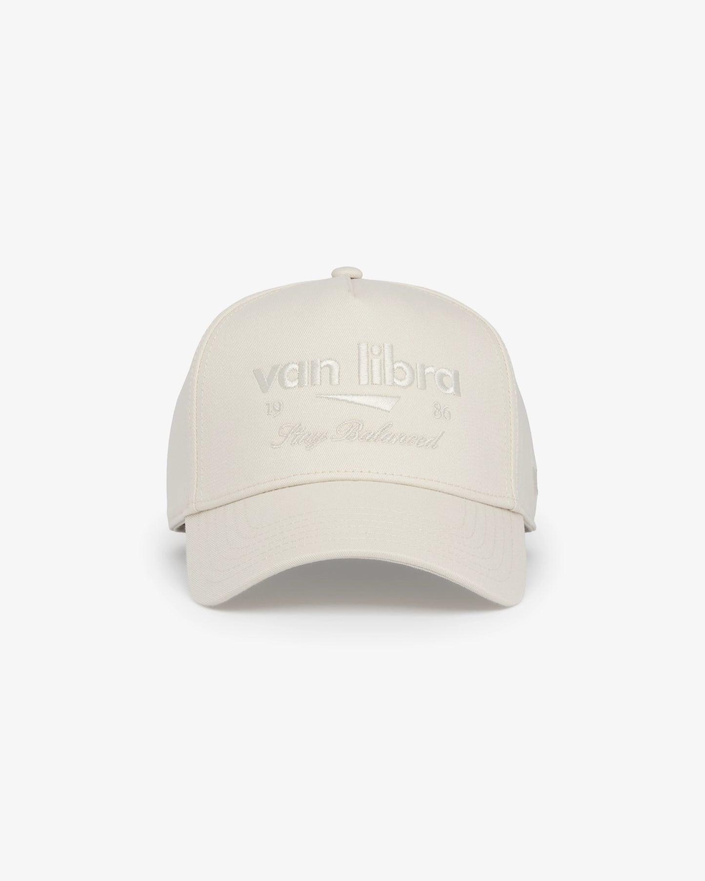 Van Libra Ivory (cream) structured cap with ivory crown and brim. Features cream colored embroidered text “van libra” with abstract triangle graphic on the front, “1986” and “Stay Balanced” lettering on the front, plus “VL” stitched on the side, finished with an adjustable ivory snapback closure at the back.