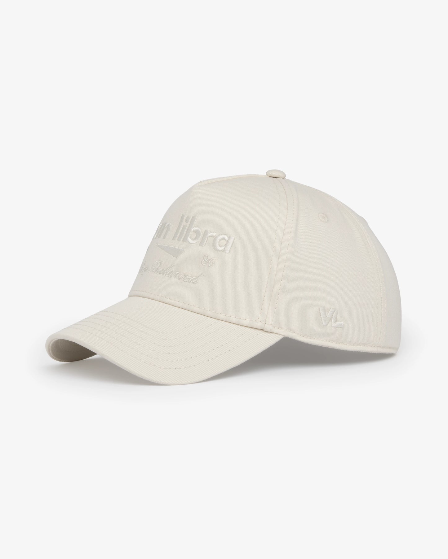 Van Libra Ivory (cream) structured cap with ivory crown and brim. Features cream colored embroidered text “van libra” with abstract triangle graphic on the front, “1986” and “Stay Balanced” lettering on the front, plus “VL” stitched on the side, finished with an adjustable ivory snapback closure at the back.