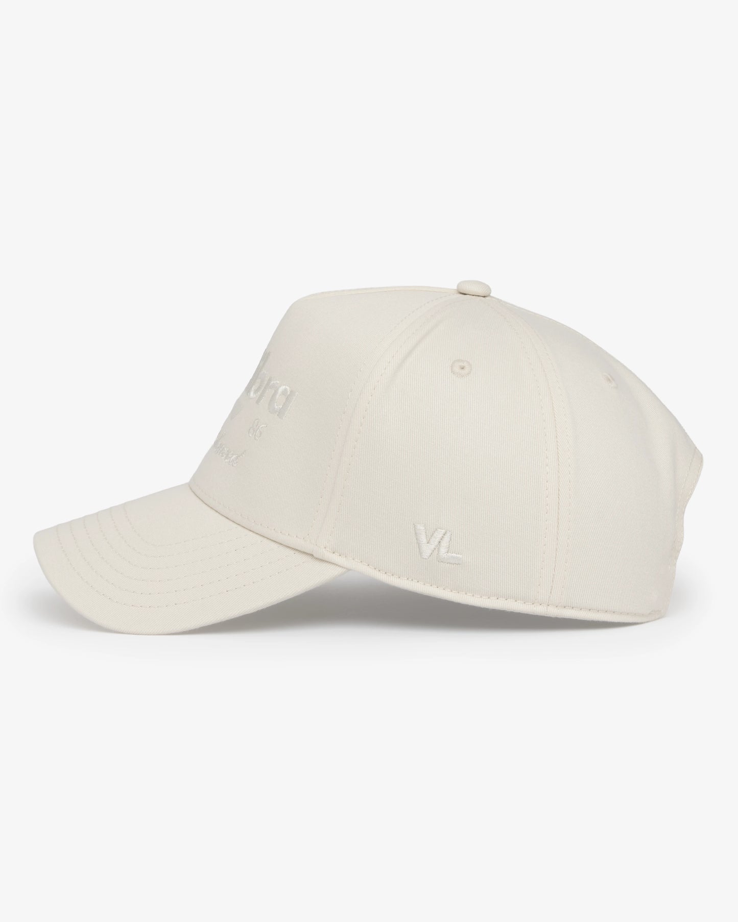 Van Libra Ivory (cream) structured cap with ivory crown and brim. Features cream colored embroidered text “van libra” with abstract triangle graphic on the front, “1986” and “Stay Balanced” lettering on the front, plus “VL” stitched on the side, finished with an adjustable ivory snapback closure at the back.