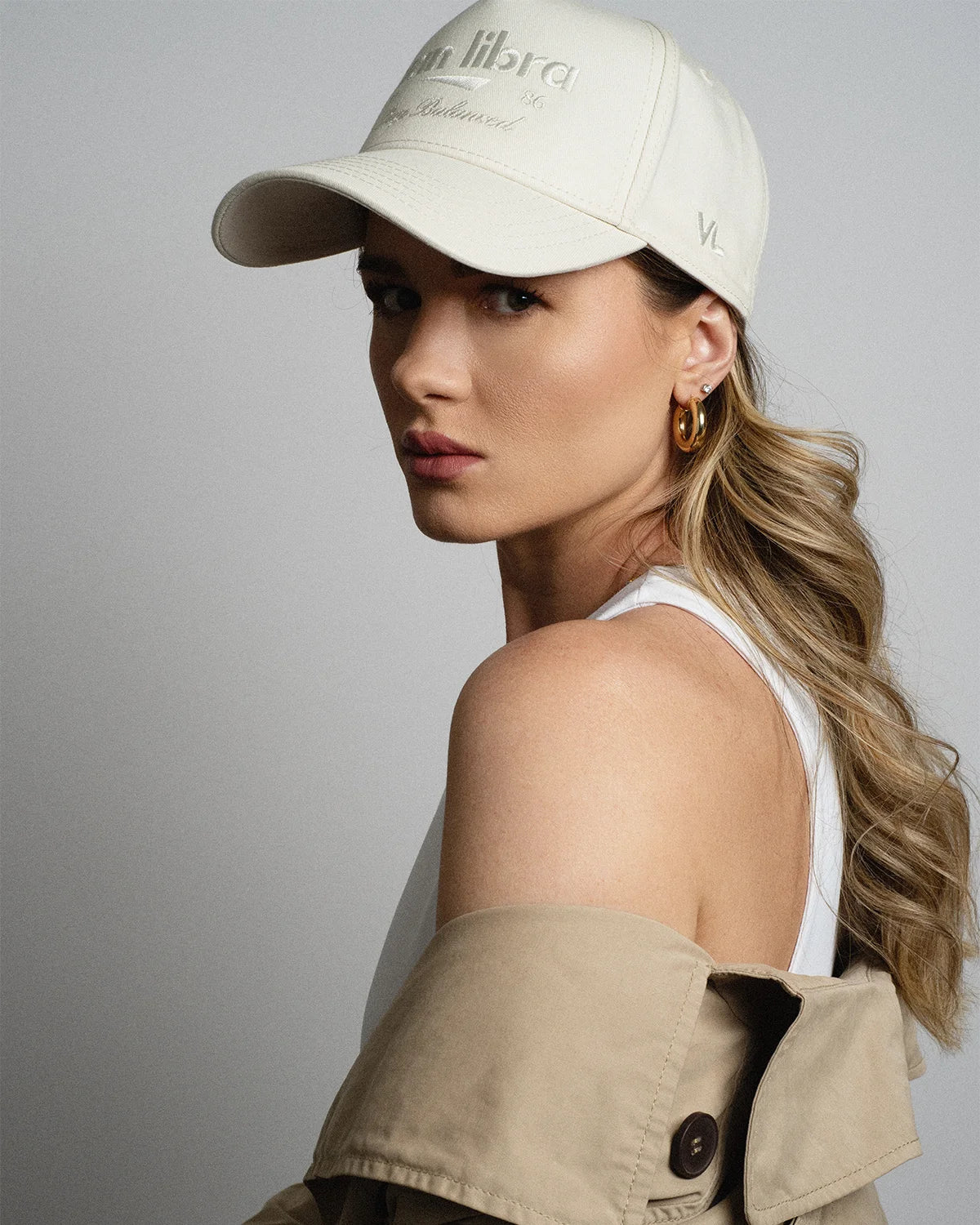 Van Libra Ivory (cream) structured cap with ivory crown and brim. Features cream colored embroidered text “van libra” with abstract triangle graphic on the front, “1986” and “Stay Balanced” lettering on the front, plus “VL” stitched on the side, finished with an adjustable ivory snapback closure at the back.