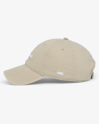 Van Libra Dune (beige) dad hat with white embroidered text “Stay Balanced” on the front, “1986” stitched on the side, and “VAN LIBRA” on the back above an adjustable strap with brass buckle.