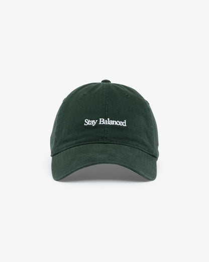 Van Libra Forest (dark green) dad hat with white embroidered text “Stay Balanced” on the front, “1986” stitched on the side, and “VAN LIBRA” on the back above an adjustable strap with brass buckle.