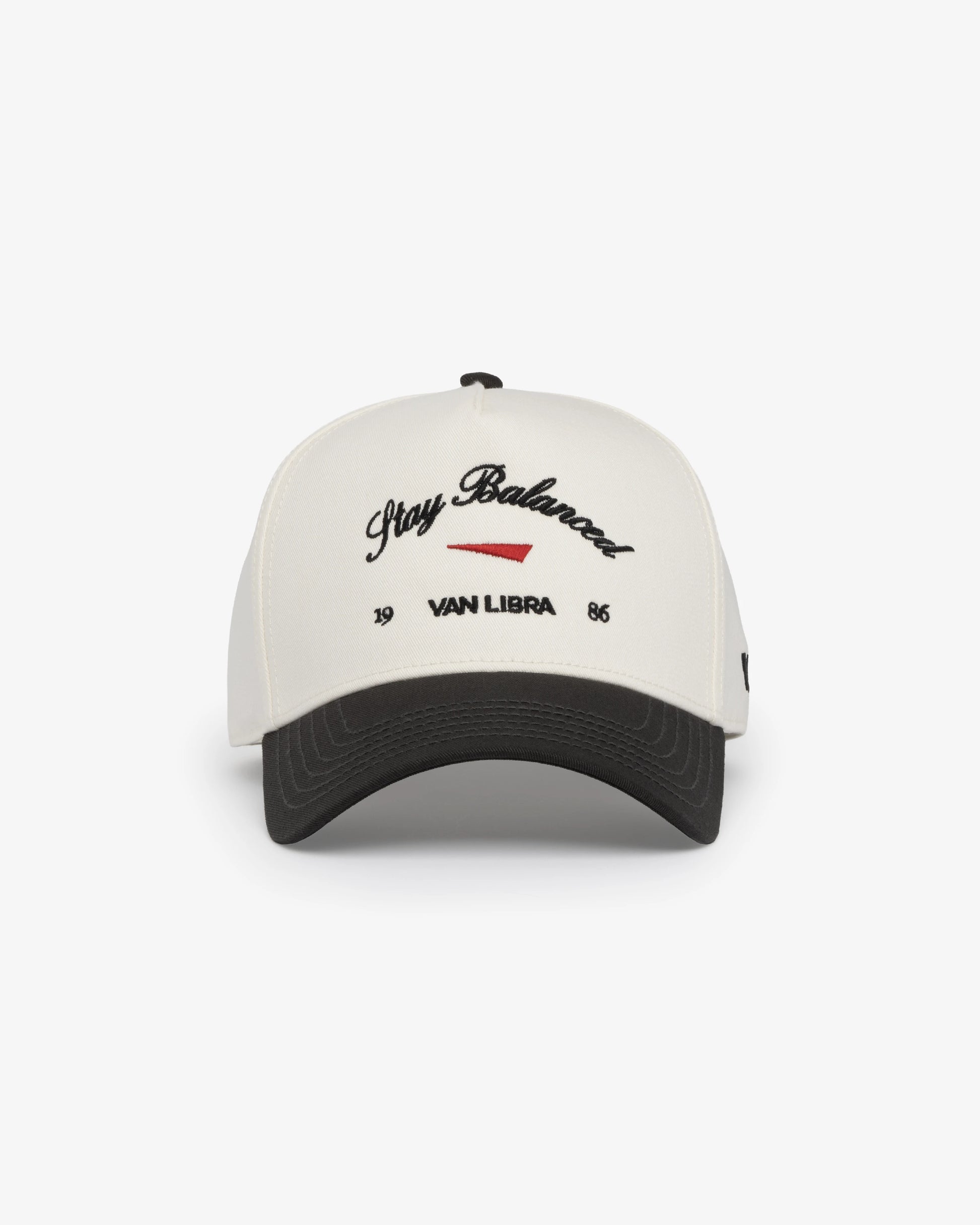 Van Libra Bone/Carbon (cream and dark gray) structured cap with bone colored crown and carbon colored brim. Features black embroidered text “Stay Balanced” with red abstract triangle graphic on the front, black “1986” and “VAN LIBRA” details, and “VL” stitched on the side, finished with an adjustable carbon colored snapback closure at the back.