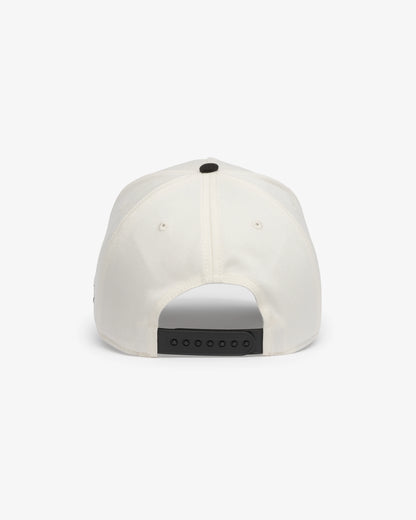 Van Libra Bone/Carbon (cream and dark gray) structured cap with bone colored crown and carbon colored brim. Features black embroidered text “Stay Balanced” with red abstract triangle graphic on the front, black “1986” and “VAN LIBRA” details, and “VL” stitched on the side, finished with an adjustable carbon colored snapback closure at the back.