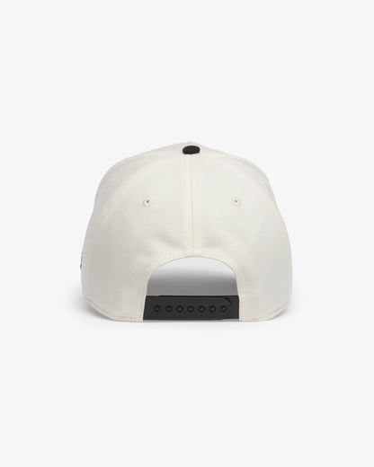Van Libra Bone/Carbon (cream and dark gray) structured cap with bone colored crown and carbon colored brim. Features black embroidered text “Stay Balanced” with abstract triangle graphic on the front, “1986” and “VAN LIBRA” details, and “VL” stitched on the side, finished with an adjustable carbon colored snapback closure at the back.