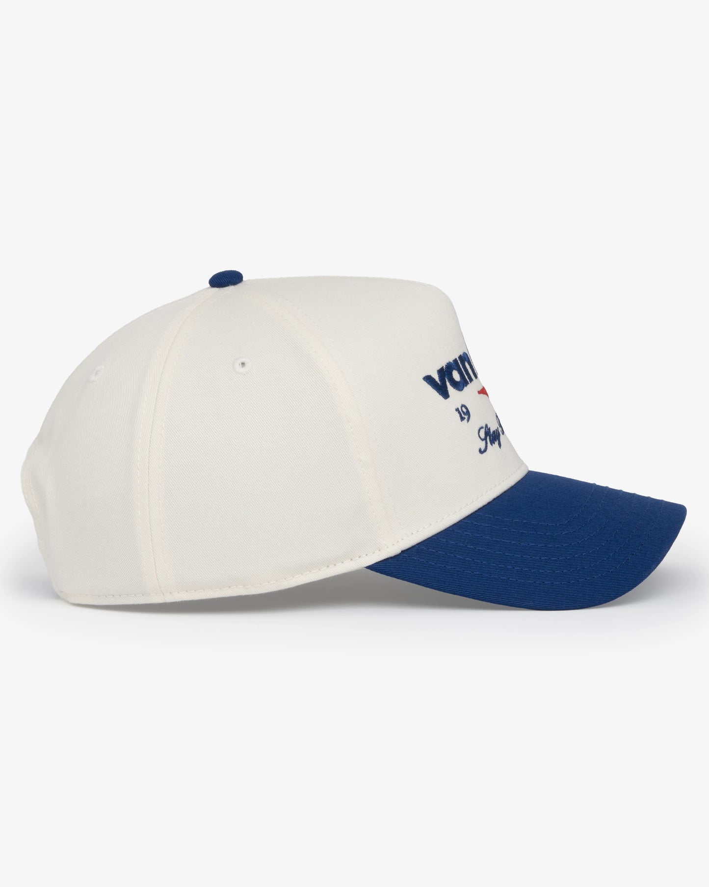 Van Libra Bone/Indigo (cream and blue) structured cap with bone colored crown and indigo colored brim. Features blue embroidered text “van libra” with red abstract triangle graphic on the front, blue “1986” and “Stay Balanced” lettering on the front, plus “VL” stitched on the side, finished with an adjustable indigo snapback closure at the back.