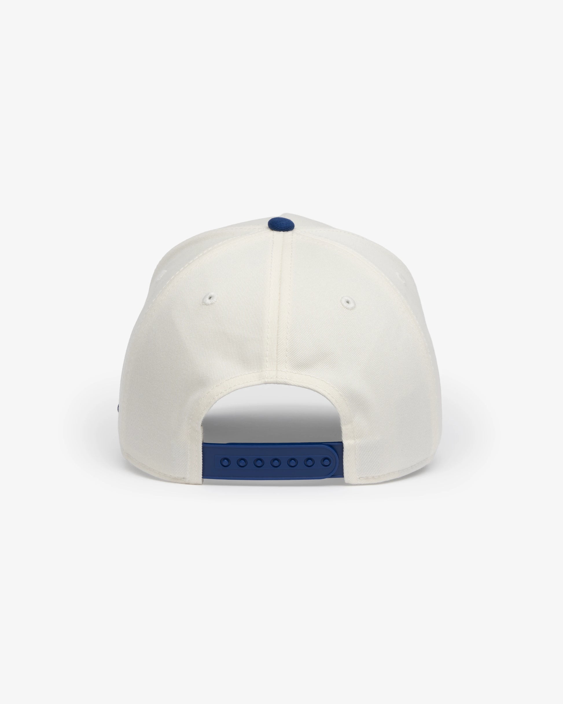 Van Libra Bone/Indigo (cream and blue) structured cap with bone colored crown and indigo colored brim. Features blue embroidered text “van libra” with red abstract triangle graphic on the front, blue “1986” and “Stay Balanced” lettering on the front, plus “VL” stitched on the side, finished with an adjustable indigo snapback closure at the back.