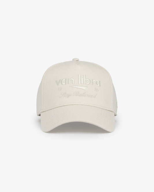 Van Libra Ivory (cream) structured cap with ivory crown and brim. Features cream colored embroidered text “van libra” with abstract triangle graphic on the front, “1986” and “Stay Balanced” lettering on the front, plus “VL” stitched on the side, finished with an adjustable ivory snapback closure at the back.
